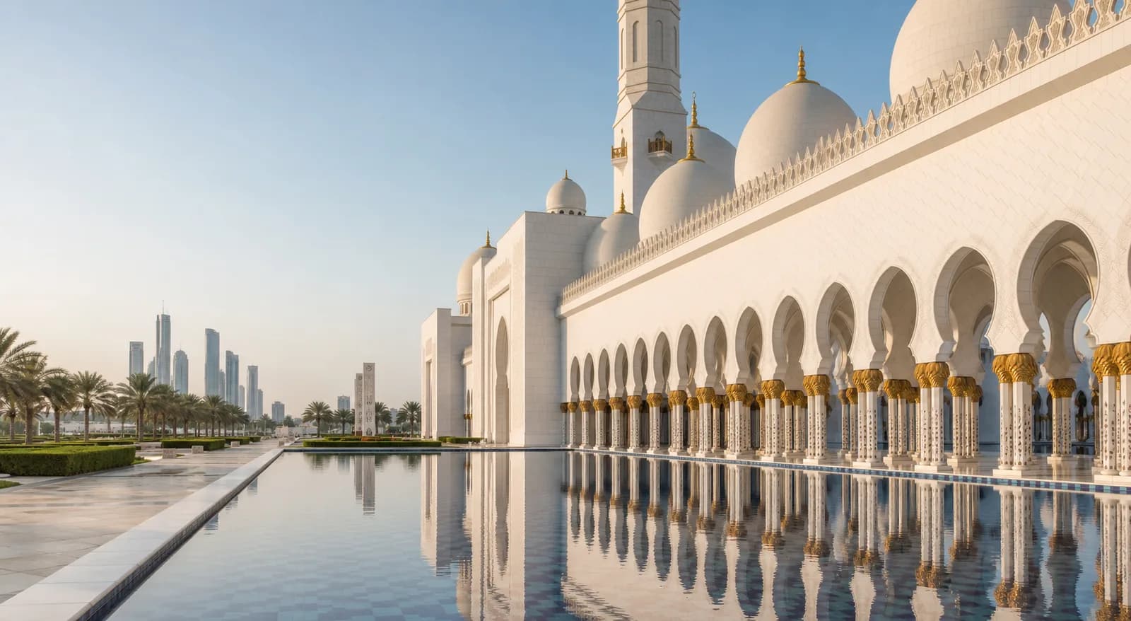 Sheikh Zayed Grand Mosque reflected in pools with Abu Dhabi skyline beyond