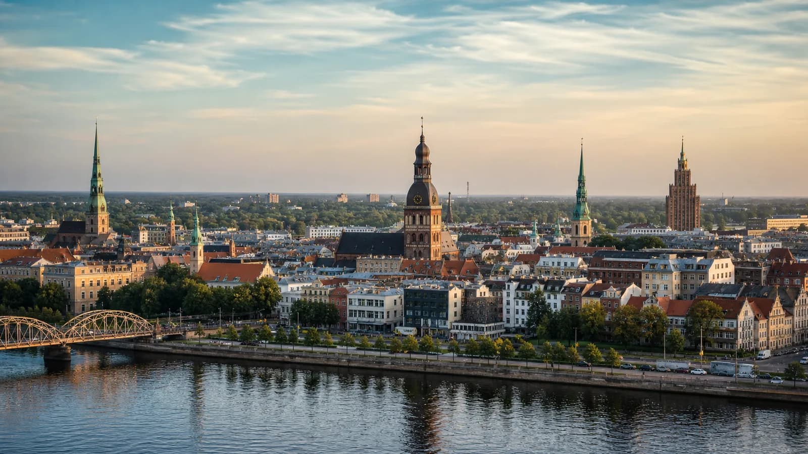 Riga old town spires and rooftops beside the Daugava river in warm light
