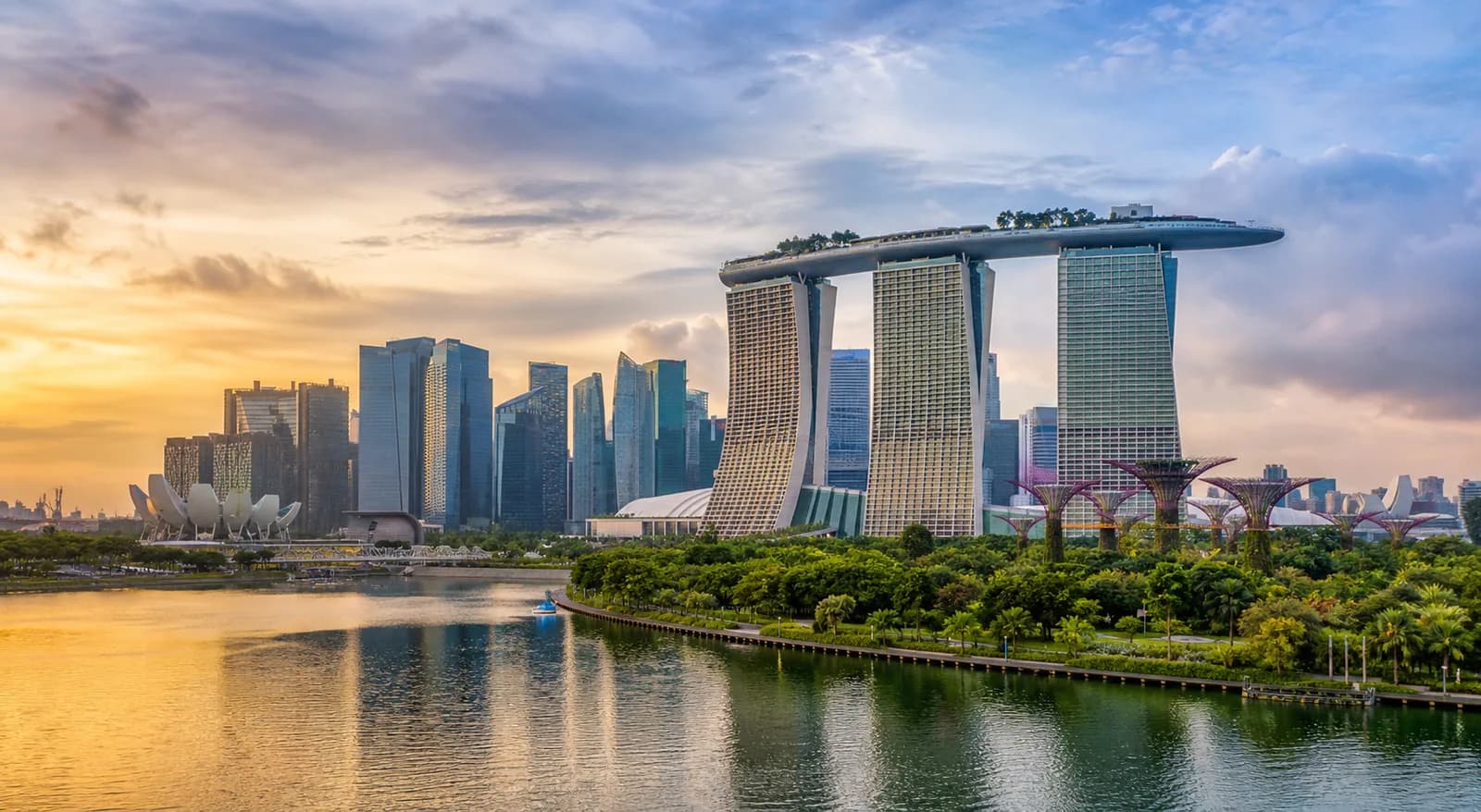 Marina Bay Sands and the Singapore skyline reflected beside tropical waterfront gardens